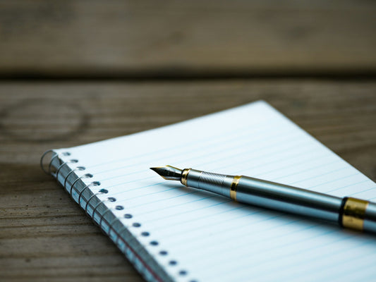 Notebook and pen placed on a desk for Hindi script writing practice
